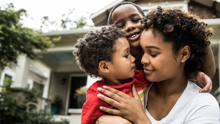 Mother and two kids infront of their home in the US